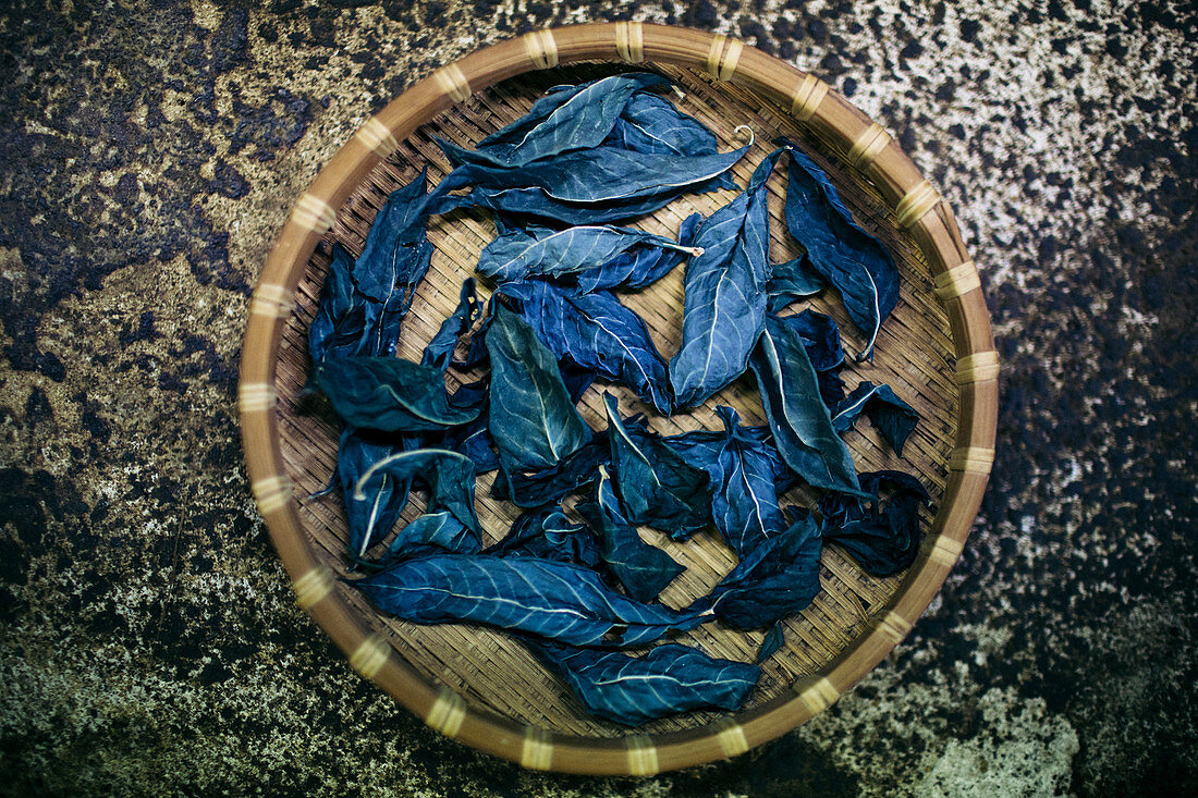 High angle close up of basket with indigo leaves used to dye cotton.