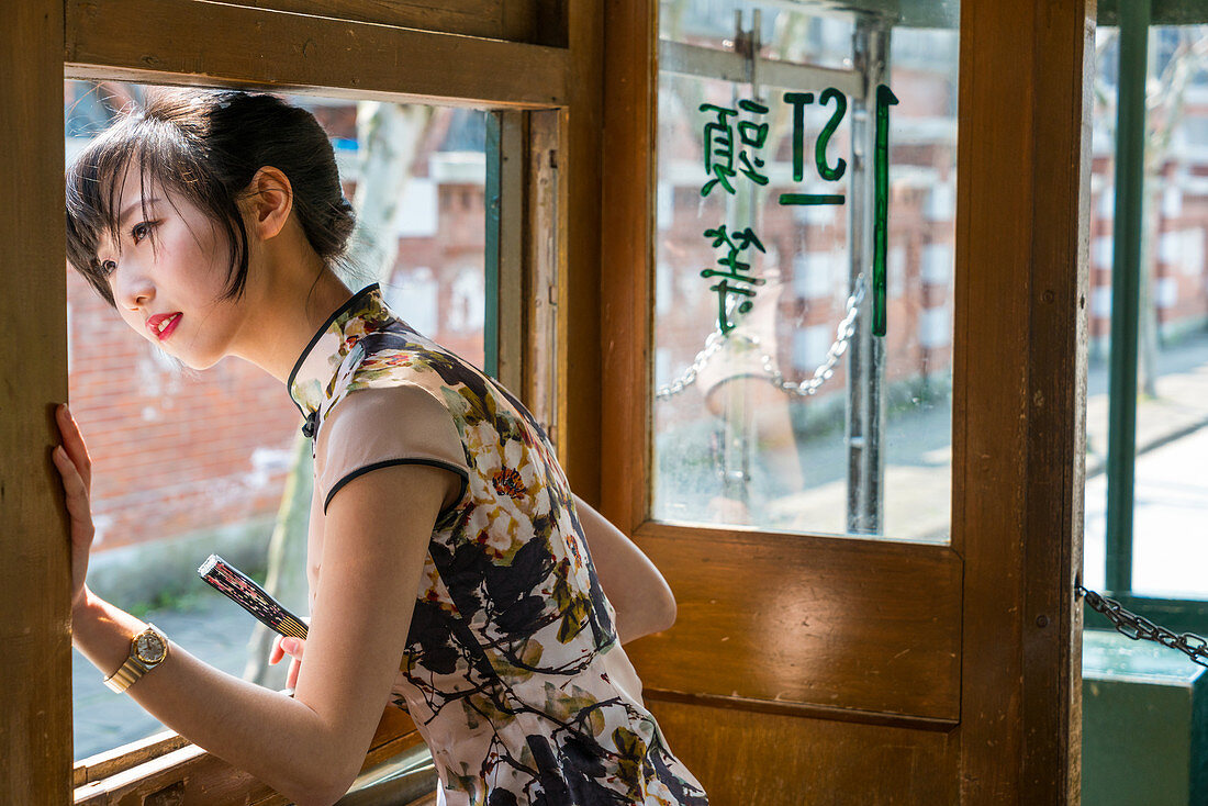 Junge chinesische Frau in der alten Straßenbahn, Shanghai, China