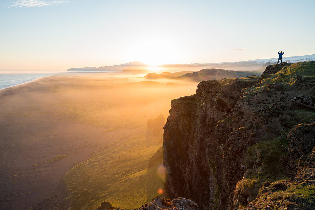 Man looking at the view at sunset from Dyrholaey Peninsula, near Vik, South Iceland (Sudurland), Iceland, Polar Regions