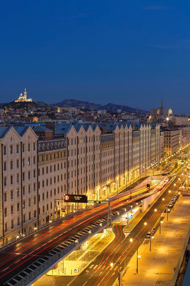 Frankreich, Bouches-du-Rhône, Marseille, Gebiet von Euroméditerranée, Bezirk La Joliette, Küstenboulevard, Les Docks, A55 und Eingangstunnel von La Joliette vom Silo, Basilika Notre Dame de la Garde Hintergrund