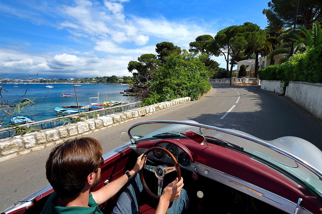 France, Alpes Maritimes, Antibes, Cap d'Antibes, along the Gulf Juan on the Boulevard Maréchal Juin aboard a collection convertible Porsche Speedster 356