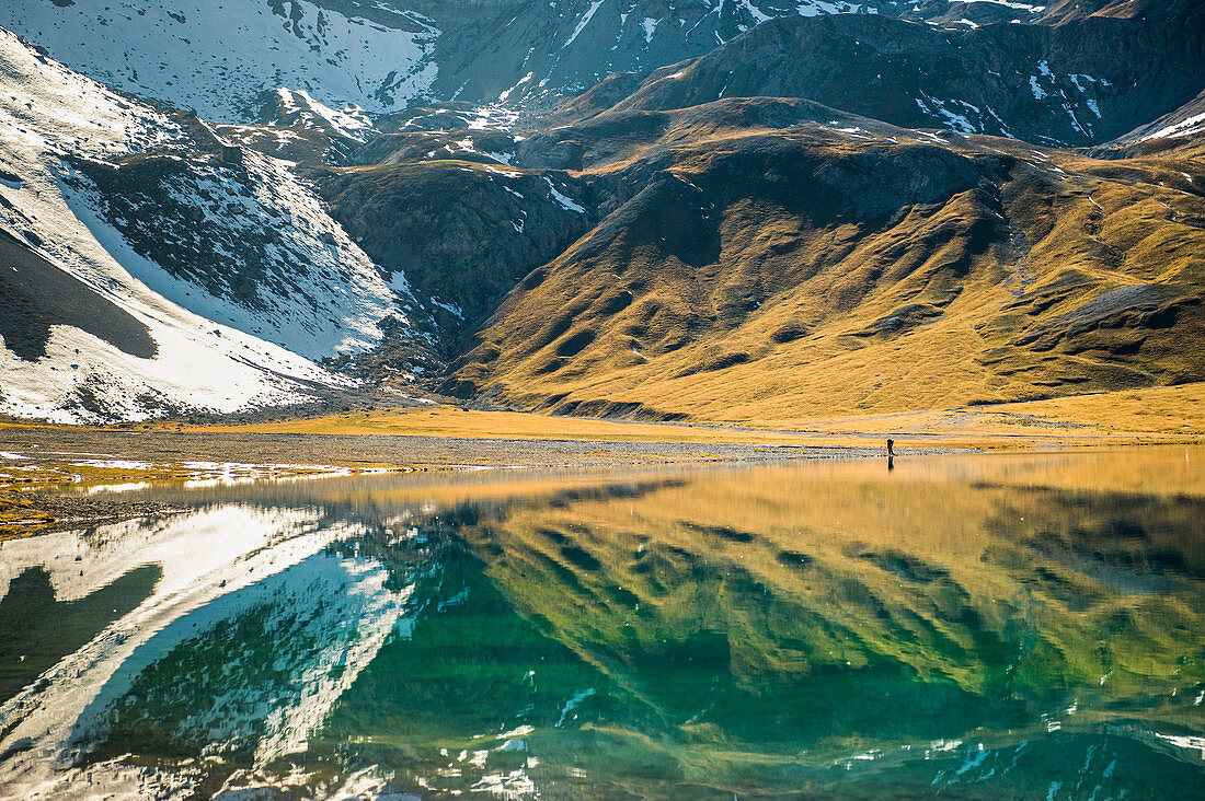 Wanderer und Bündner Berglandschaft spiegeln sich im Bergsee, Lai da Rims, Graubünden, Schweiz, Europa