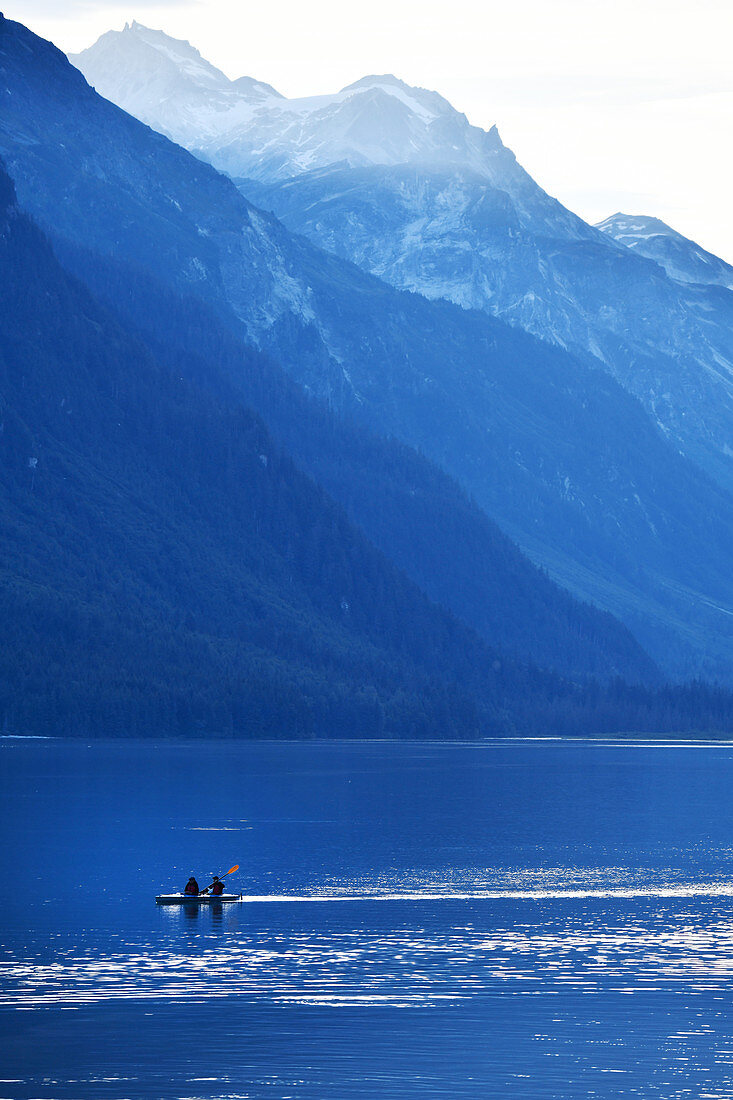 Kayakers in the sea against a mountain backdrop. Heines, Alaska,