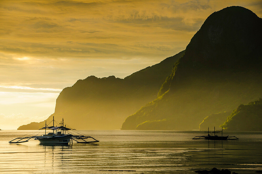 Outrigger at sunset in the bay of El Nido, Bacuit Archipelago, Palawan, Philippines, Southeast Asia, Asia