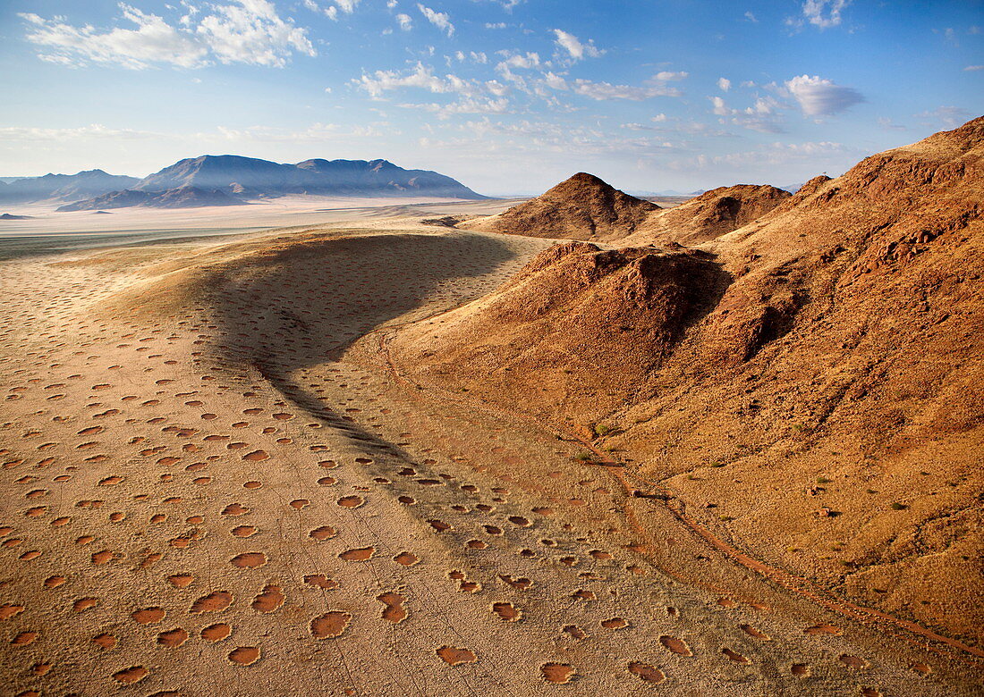 Luftaufnahme vom Heißluftballon über herrliche Wüstenlandschaft von Sanddünen, Bergen und Feenkreisen, Namib Rand Wildreservat Namib Naukluft Park, Namibia, Afrika