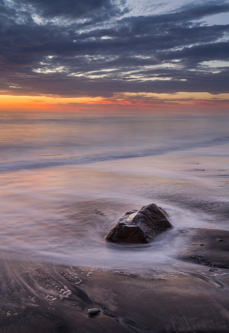 Sonnenuntergang am Strand an der Westküste Kaliforniens mit Wellen, USA\n