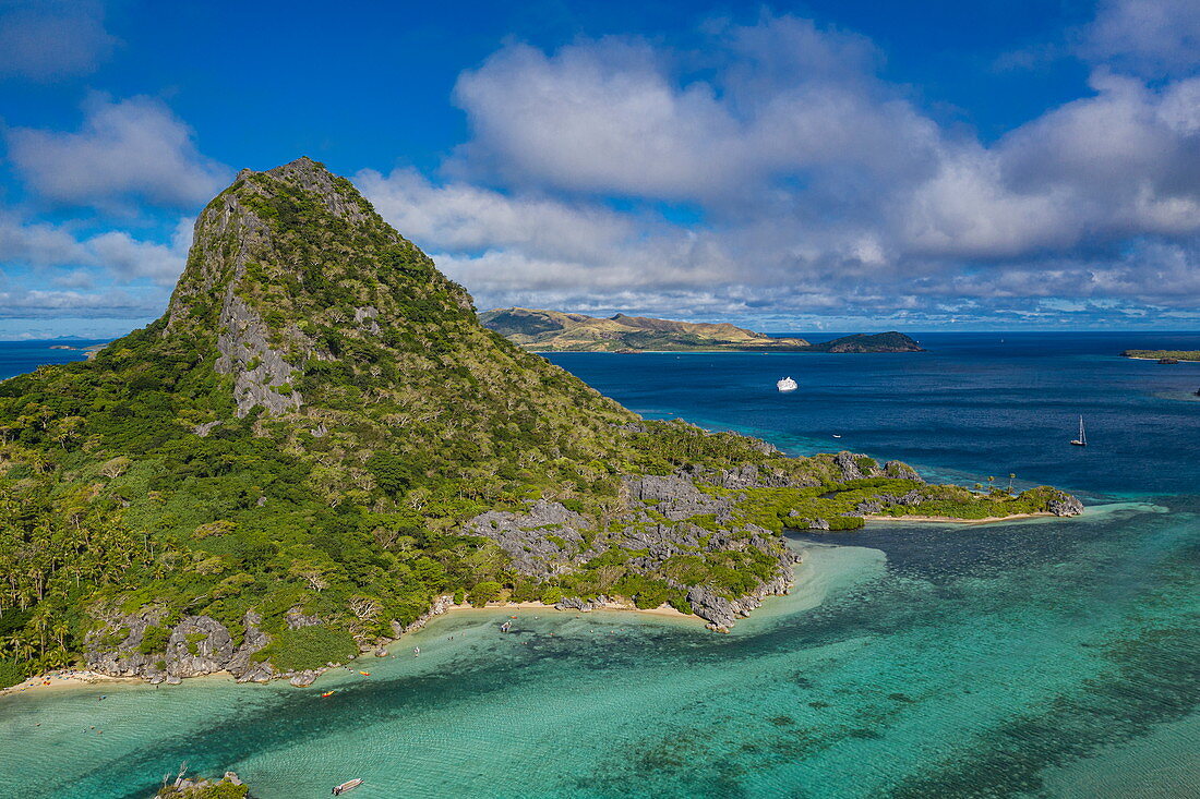 Luftaufnahme des Berges Sawa-i-Lau mit Kreuzfahrtschiff in der Ferne, Insel Sawa-i-Lau, Yasawa Group, Fidschi, Südpazifik