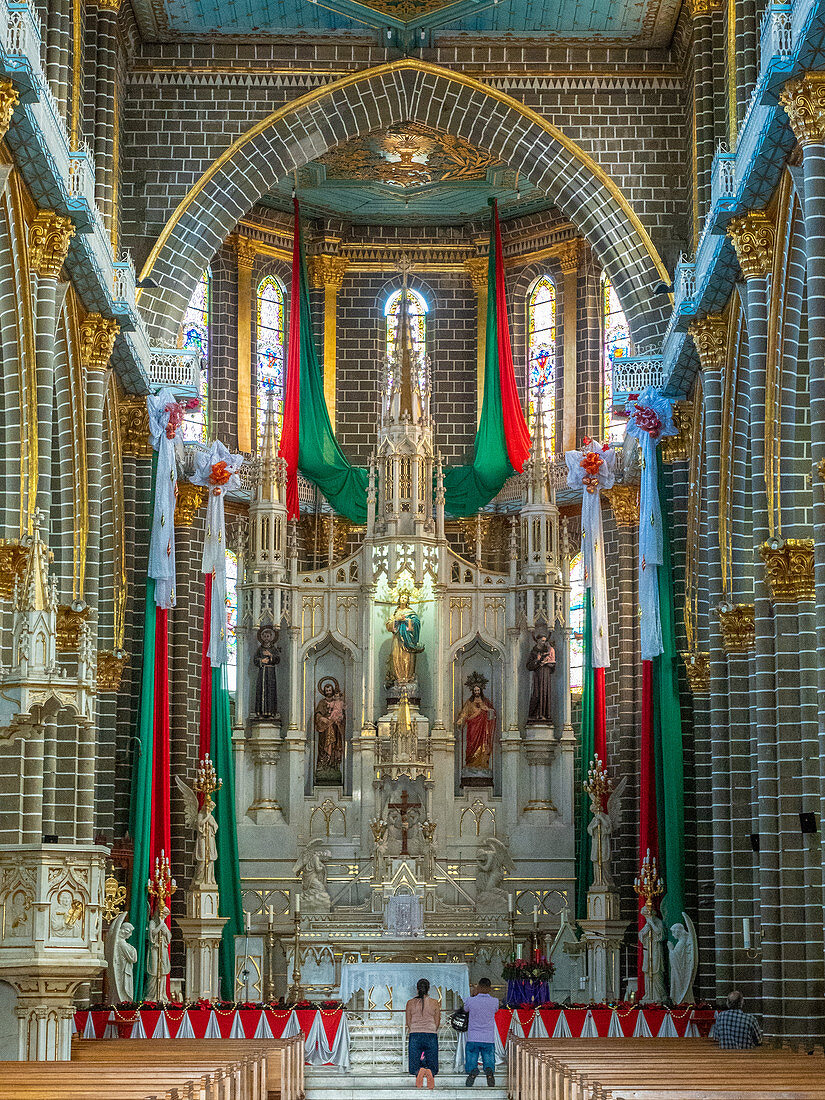 People kneeling at the central altar, Basilica Menor de la Immaculada Concepcion, Jardin, Antioquia, Colombia, South America