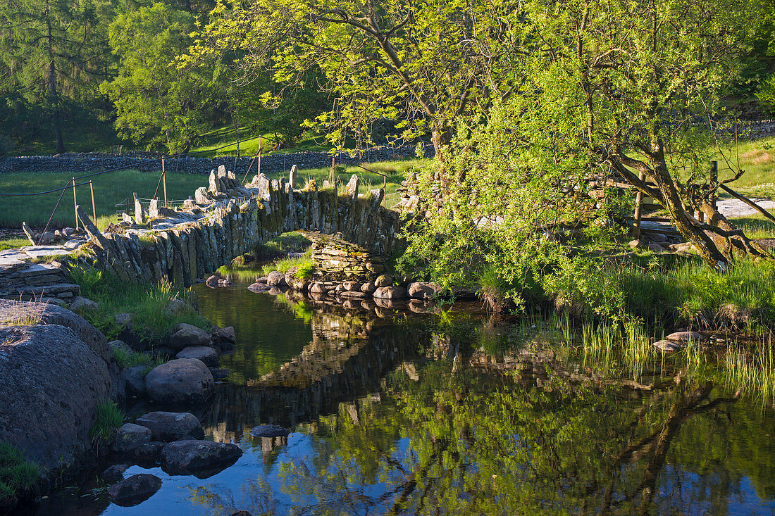 Slater's Bridge aus dem 16. Jahrhundert, reflektiert im Fluss Brathay, Little Langdale, Nationalpark Lake District, UNESCO-Weltkulturerbe, Cumbria, England, Vereinigtes Königreich, Europa