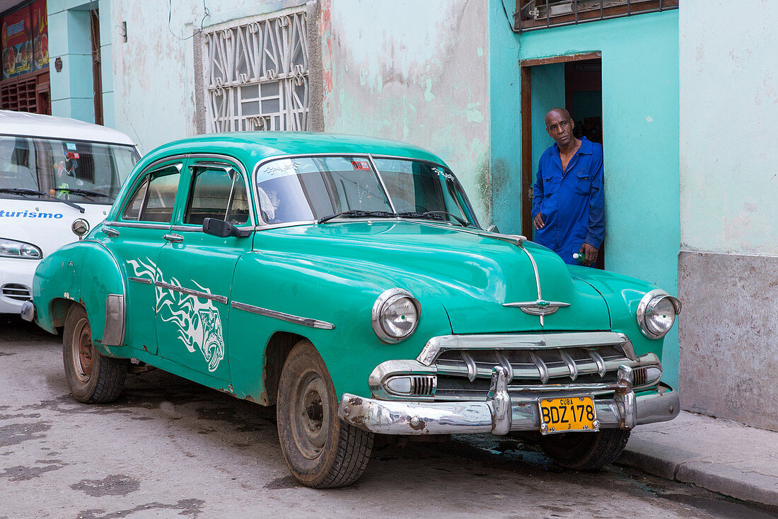 Mechanic with green classic car in Havana, Cuba