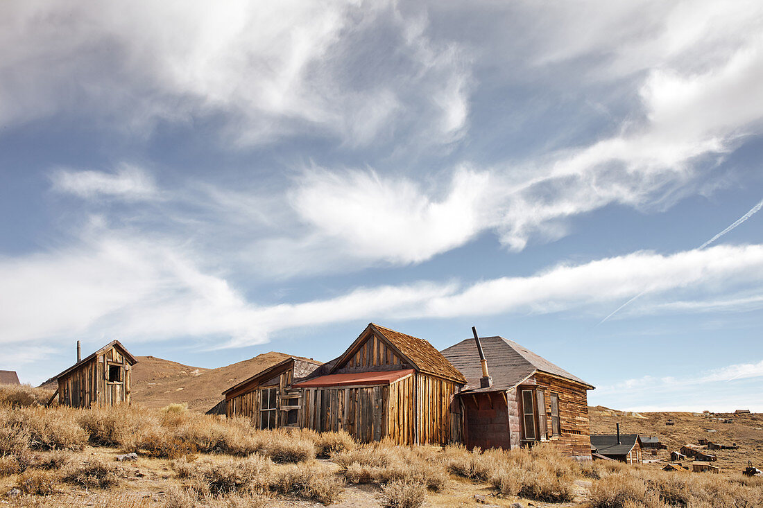Buildings in the ghost town of Bodie under a cloudy sky in the Eastern Sierra, California, USA.