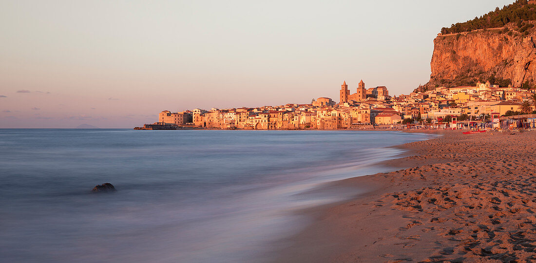 Skyline der Stadt Cefalu mit Strand bei Sonnenuntergang, Sizilien, Italien
