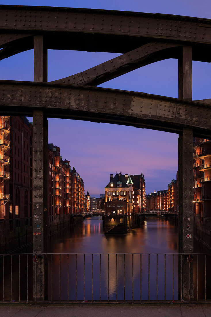 Hamburg Speicherstadt on the Poggenmuehlen-Bruecke with moated castle at sunset, Germany