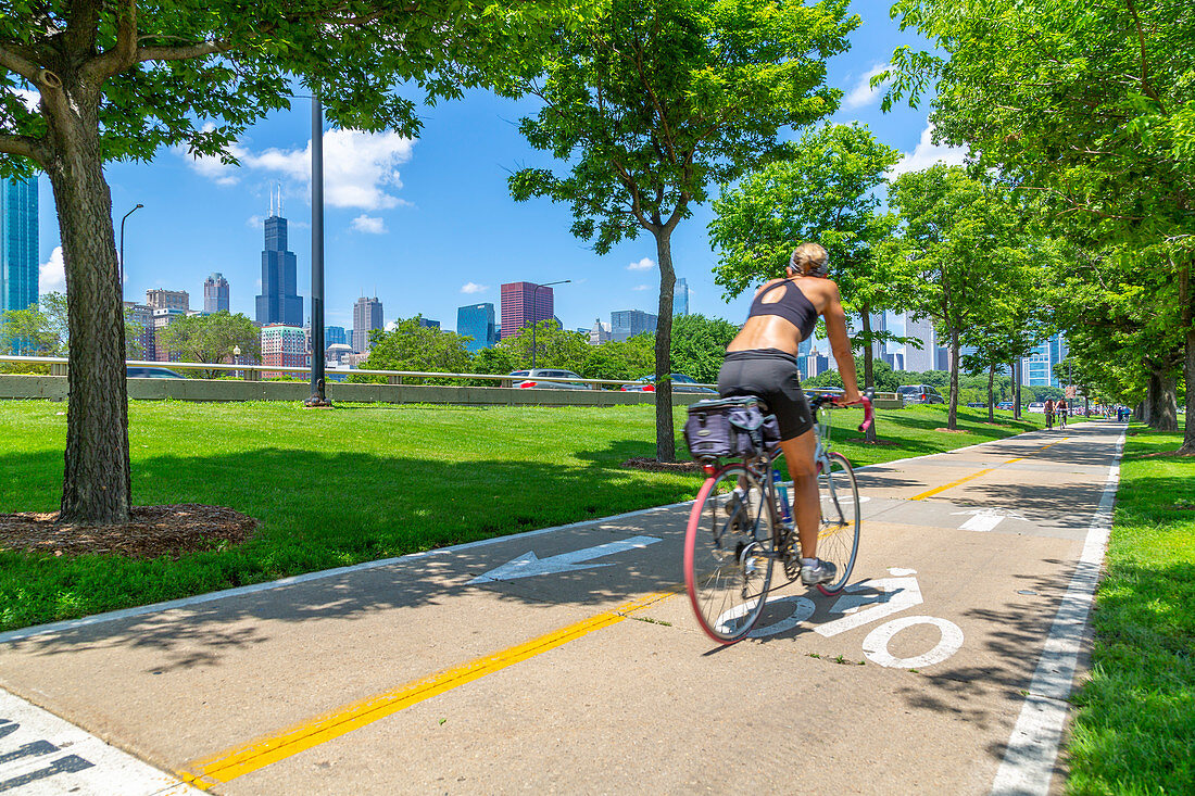Ansicht von Chicago Skyline und Radfahrer auf South Lake Shore Drive, Chicago, Illinois, Vereinigte Staaten von Amerika, Nordamerika