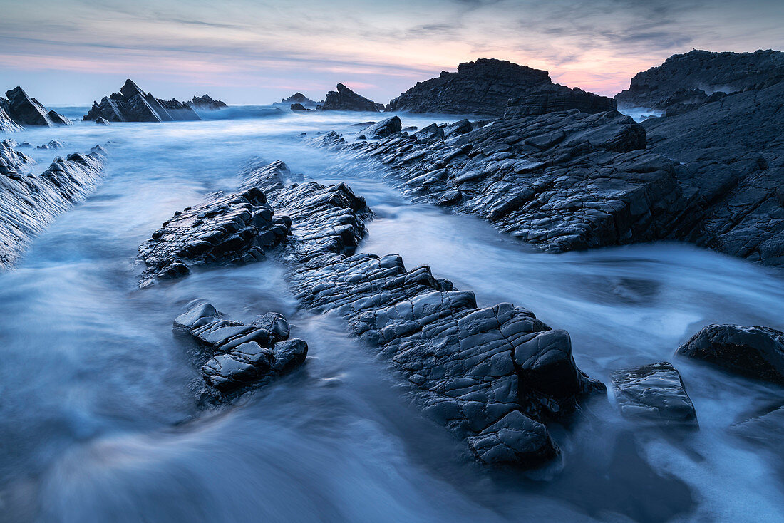 Wellen und nasse Felsvorsprünge am Hartland Quay in Nord-Devon bei Sonnenuntergang, Devon, England, Vereinigtes Königreich, Europa
