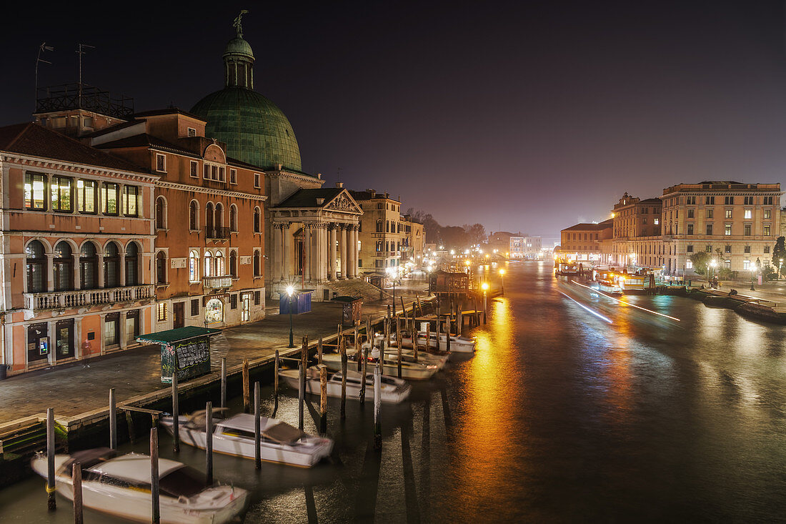 Grand Canal night view of San Simeon Piccolo with traditional buildings and wooden wharf pilings with moored boats, Venice, UNESCO World Heritage Site, Veneto, Italy, Europe