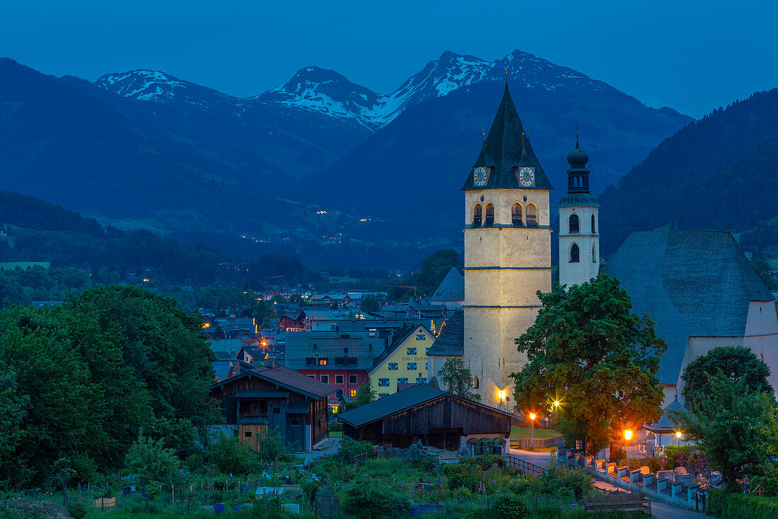 Blick auf Liebfrauenkirche und Stadt mit den umliegenden Bergen in der Abenddämmerung, Kitzbühel, Österreich Tirol, Österreich, Europa