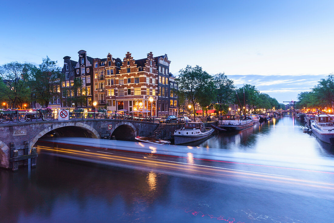 Abenddämmerung an der Brouwersgracht, Lichtstreifen von einem Touristenboot unter einer Brücke, Amsterdam, Nordholland, den Niederlanden, Europa
