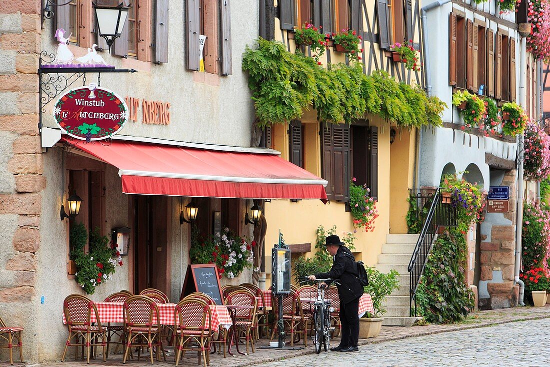 Frankreich, Haut-Rhin, Route des Vins d'Alsace (Elsässer Weinstraße), Bergheim, Mann mit Fahrrad an der Terrasse eines Cafés am Hauptplatz des Dorfes