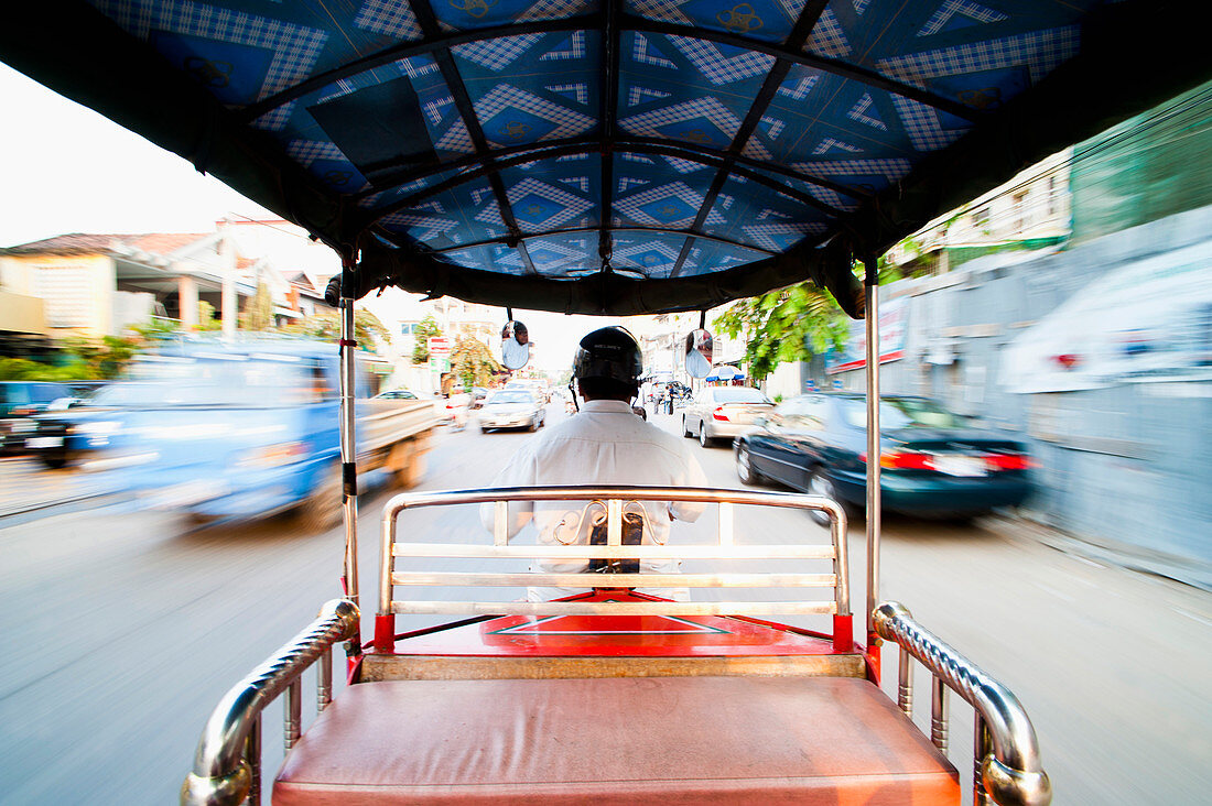 Tuktuk driver speeding along the roads of Phnom Penh, Cambodia, Indochina, Southeast Asia, Asia