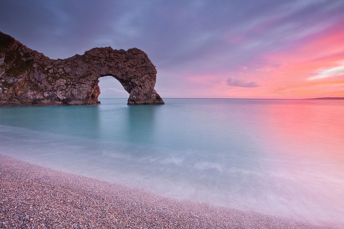 A colourful sunset over Durdle Door on the Jurassic Coast, UNESCO World Heritage Site, Dorset, England, United Kingdom, Europe