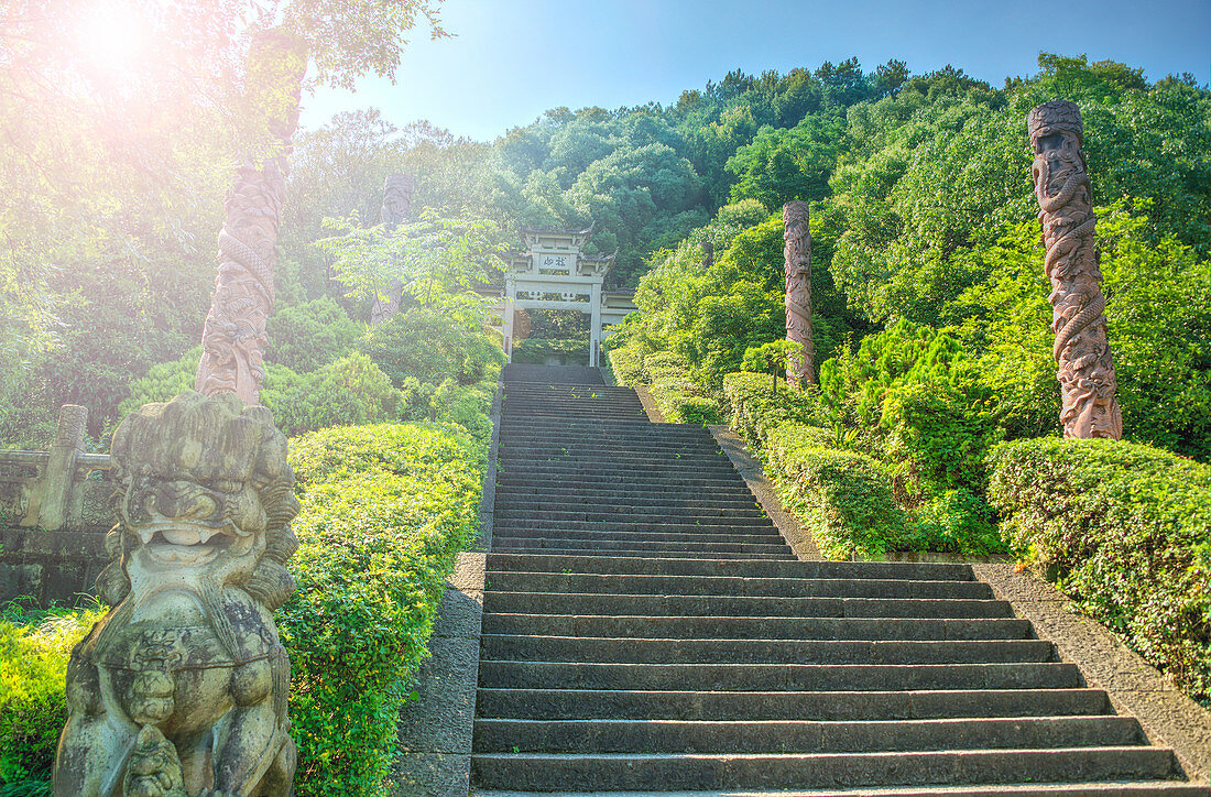 Steps flanked by stone pillars and Qi Ling lions leading up towards a stone gate, Zhejiang, China, Asia