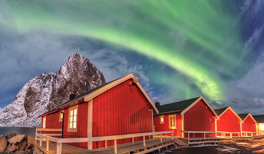 The green light of the Northern Lights (aurora borealis) lights up fishermans cabins, Hamnoy, Lofoten Islands, Arctic, Norway, Scandinavia, Europe