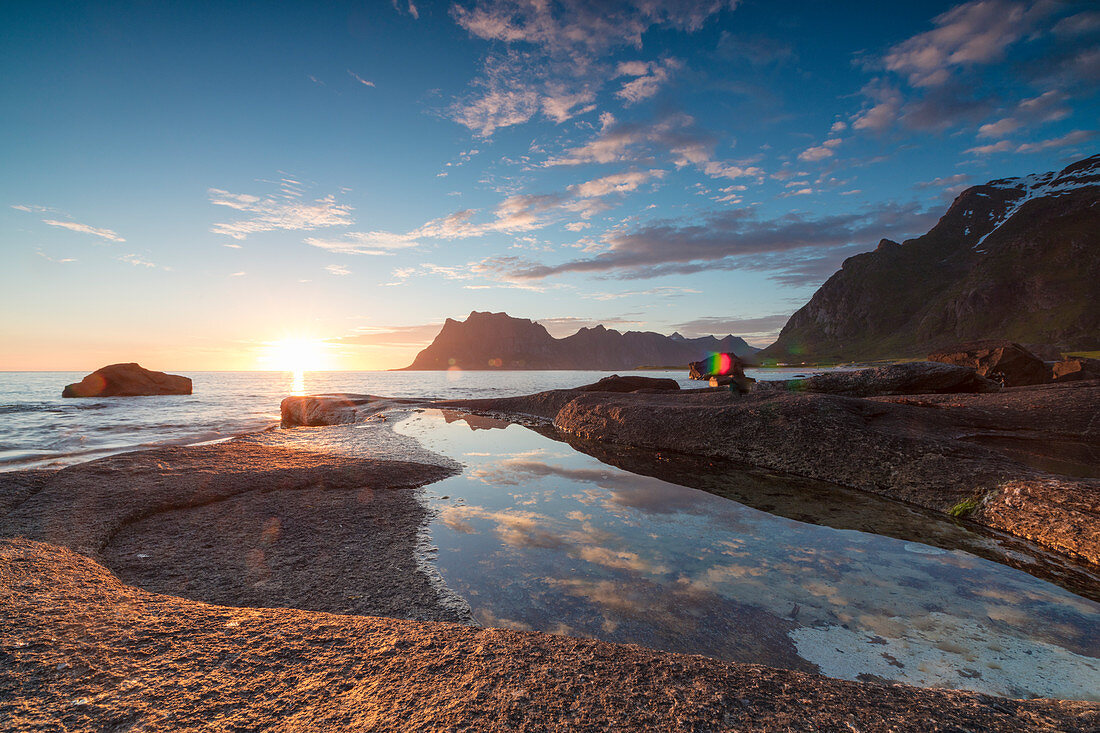 Rosa Wolken und Mitternachtssonne spiegeln sich im blauen Meer, felsigenGipfel, Uttakleiv, Lofoten, Norwegen, Skandinavien, Europa