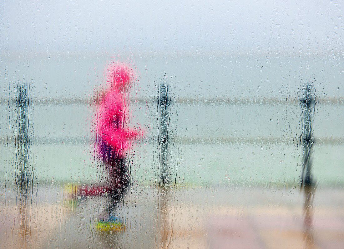 runner braving the elements on a winter seafront run, West Kirkby, Wirral, England, United Kingdom, Europe
