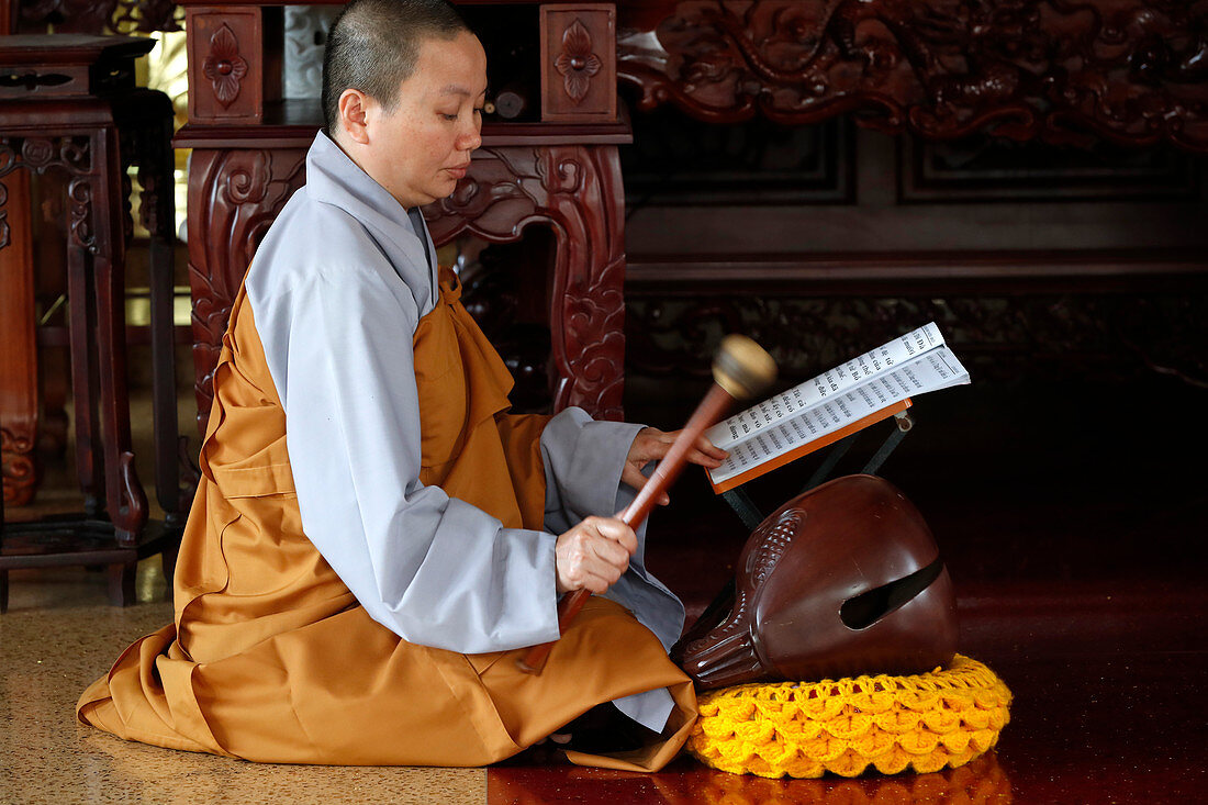 Buddhistische Zeremonie im Tempel, Mönch spielt auf einem Holzfisch (Schlaginstrument), Ho-Chi-Minh-Stadt, Vietnam, Indochina, Südostasien, Asien
