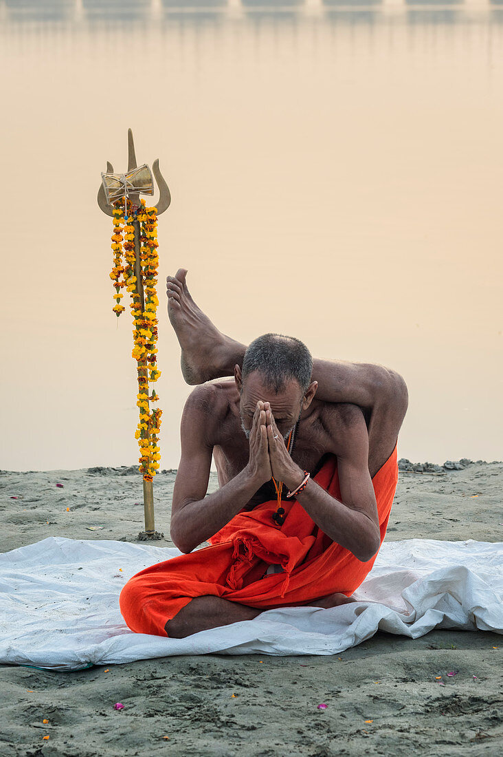 Sadhu praktiziert Yoga bei Sonnenaufgang am Ganges Flussufer, Allahabad Kumbh Mela, Allahabad, Uttar Pradesh, Indien, Asien