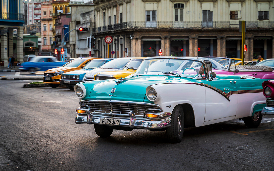 Farbenfrohe alte amerikanische Taxis parken in Havanna in der Abenddämmerung, UNESCO-Weltkulturerbe, La Habana, Kuba, Westindische Inseln, Karibik, Mittelamerika