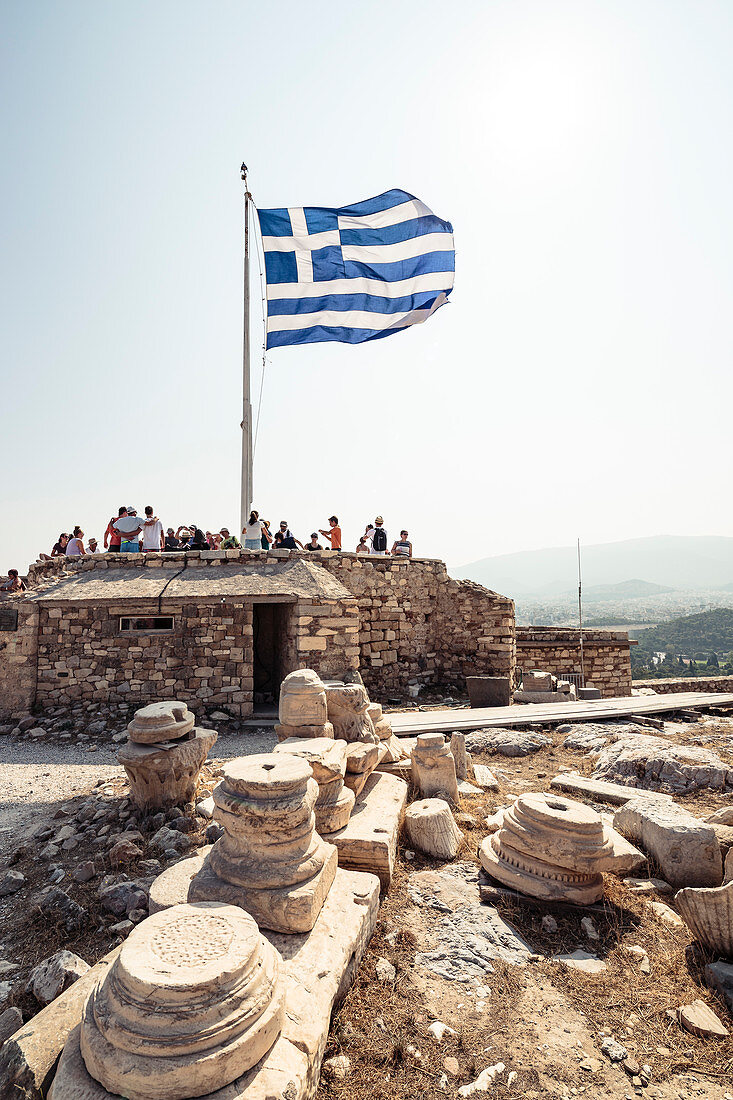Visitors under the Greek flag on the Acropolis, Athens, Greece