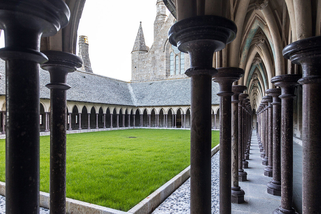 12TH CENTURY CLOISTER WITH ITS NARROW COLUMNS IN QUINCUNX CONNECTED BY ARCHES IN CAEN STONE SCULPTED WITH BAS-RELIEFS, ABBEY OF MONT-SAINT-MICHEL (50), FRANCE