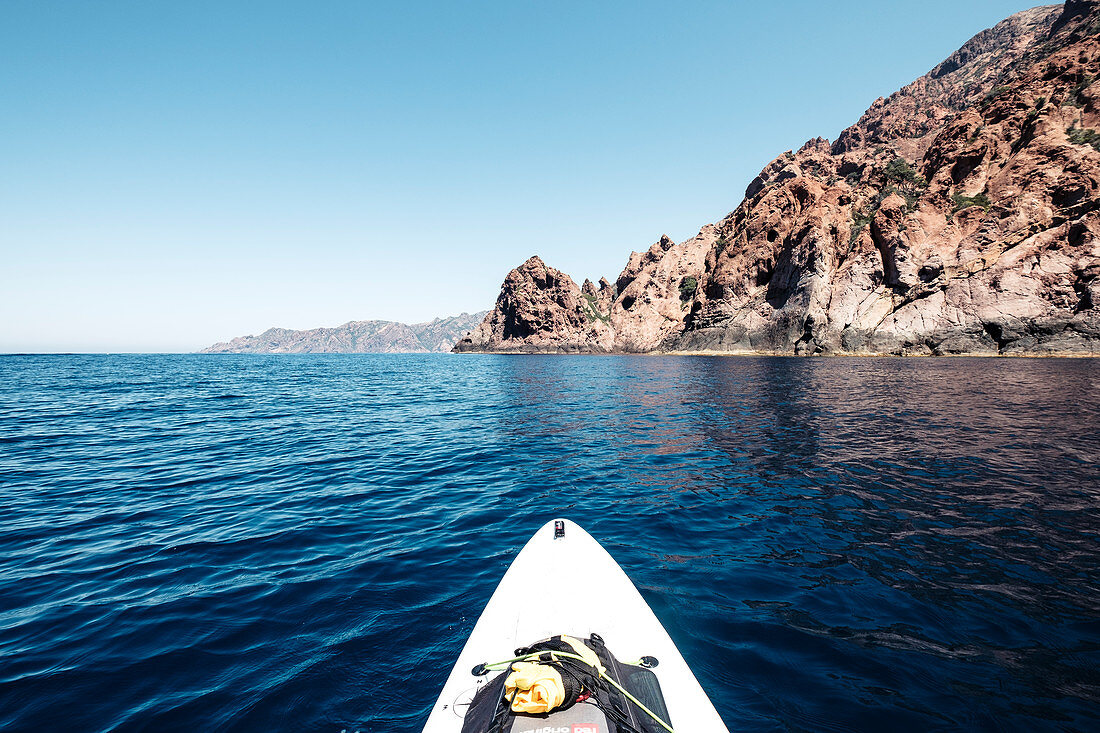 View from the stand-up paddle board at the fascinating volcanic rock in the Scandola Nature Reserve, Galeria, Calvi, Corsica, France