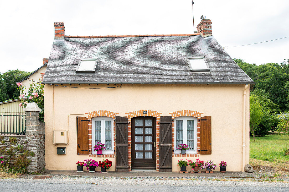 Kleines französisches Haus mit Blumentöpfen in Langon, Departement Ille-et-Vilaine, Bretagne, Frankreich, Europa