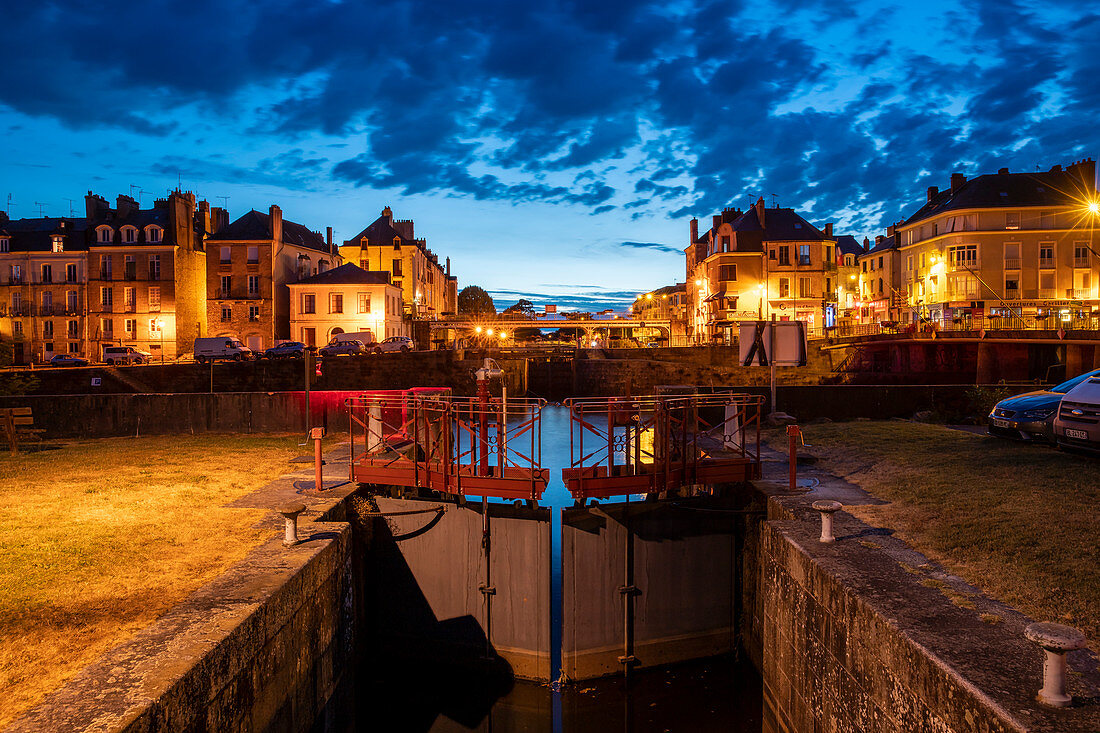 Beleuchtete Hausfassaden von Redon mit Schleuse zum Fluss Vilaine in der Dämmerung, Redon, Departement Ille-et-Vilaine, Bretagne, Frankreich, Europa