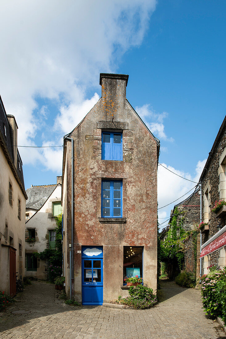 Dreamy, narrow house with blue windows between two alleys in Rochefort en Terre, Morbihan, Brittany, France, Europe