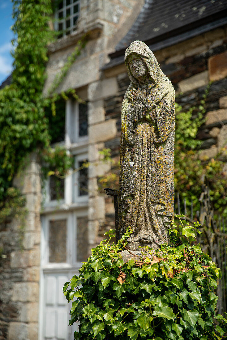 Stone statue of a praying woman in robe in the castle park, Rochefort en Terre, Morbihan department, Brittany, France, Europe