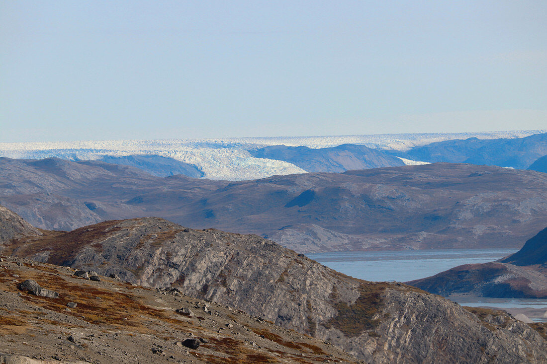 Mountain landscape with lake near Kangerlussuaq; West Greenland; autumnal tundra vegetation; rocky hilly landscape; View of the inland ice and a glacier tongue;