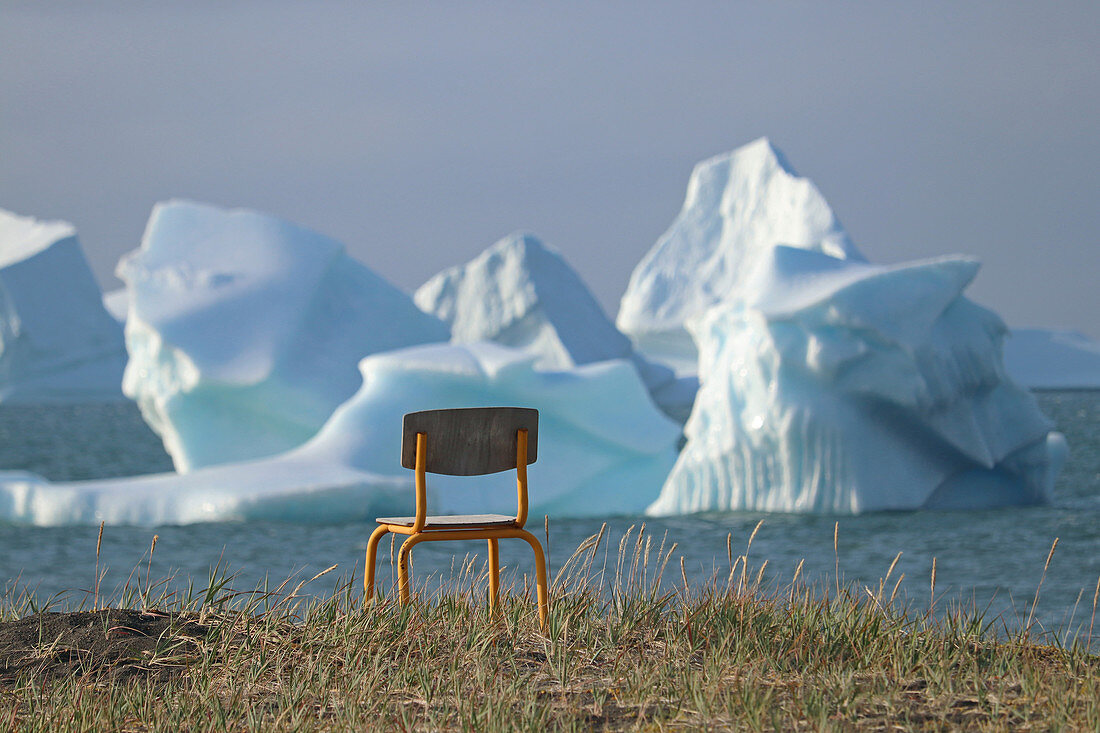 Stuhl am Ufer, Diskoinsel, Eisberge vor der Küste bei Qeqertarsuaq, Westgrönland, Grönland