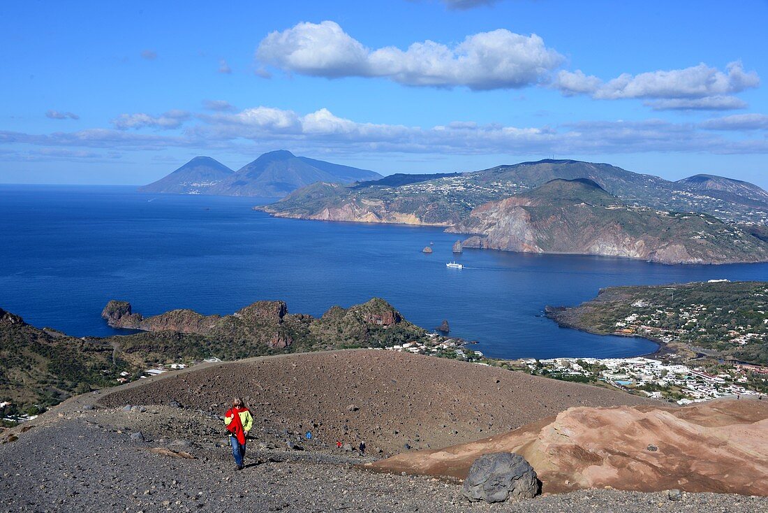 Woman on the way to the volcano with a view of Lipari, the sea and Salina, Vulkano Island, Aeolian Islands, southern Italy