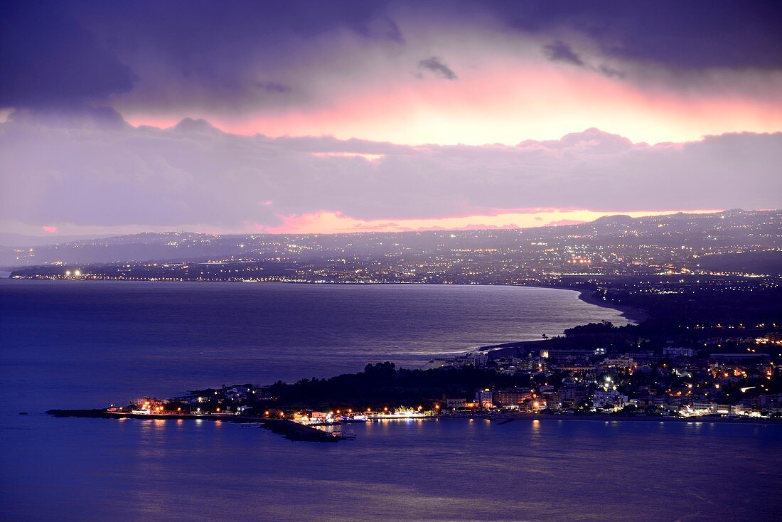 Evening view from Taormina to the south with sea and lights, east coast, Sicily, Italy