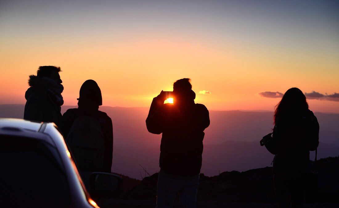 Vier Touristen bewundern Sonnenuntergang am Vulkan Ätna, Südseite, Ostküste, Sizilien, Italien