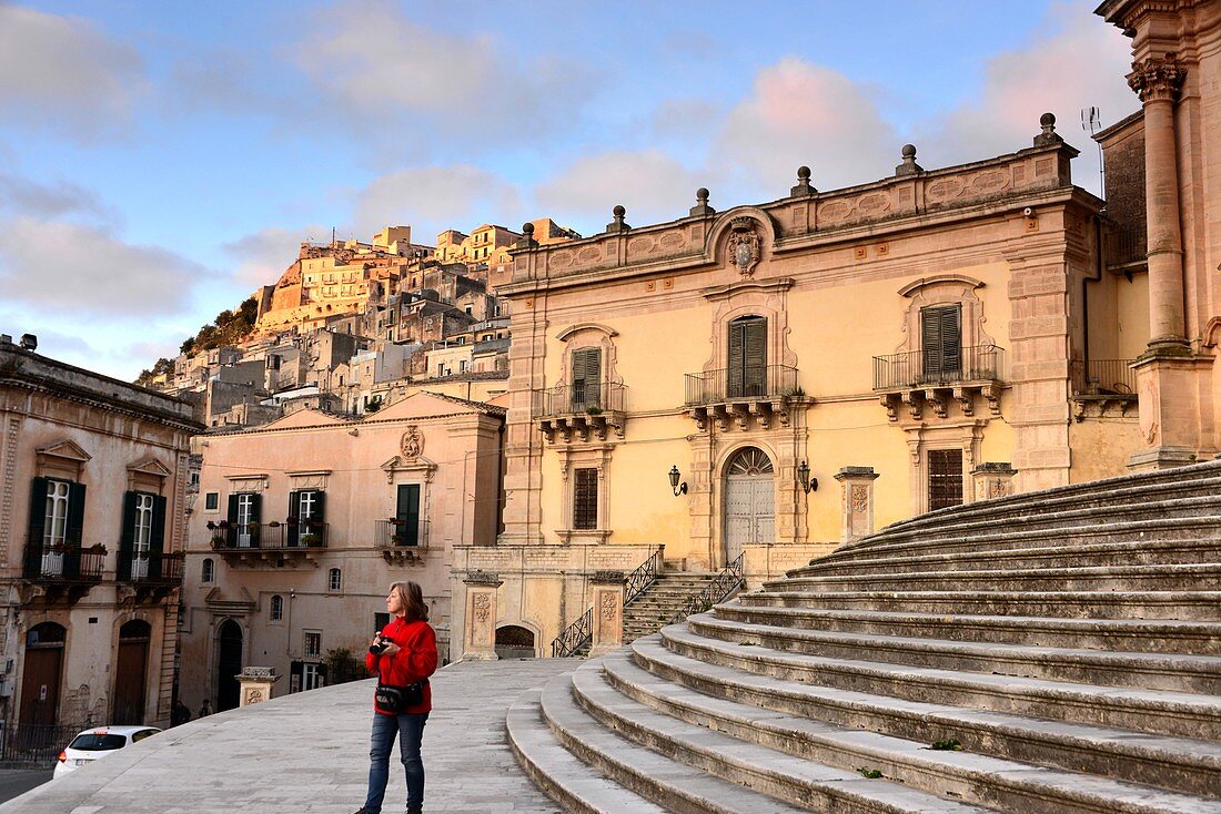 Palace, steps, woman at the Duomo, upper town of Modica, southern Sicily, Italy