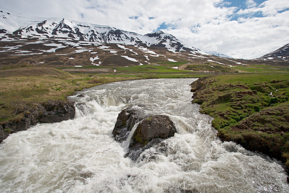 Fast flowing river with mountain backdrop Iceland LA007106