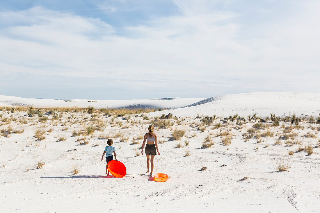 Kinder ziehen Schlitten hinter sich, White-Sands-Nationalpark, New Mexico, Vereinigte Staaten