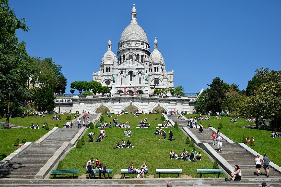 Frankreich, Paris, Basilika Sacre-Coeur von Montmartre, von Rasenflächen umgebene Treppe am Fuße eines religiösen Gebäudes