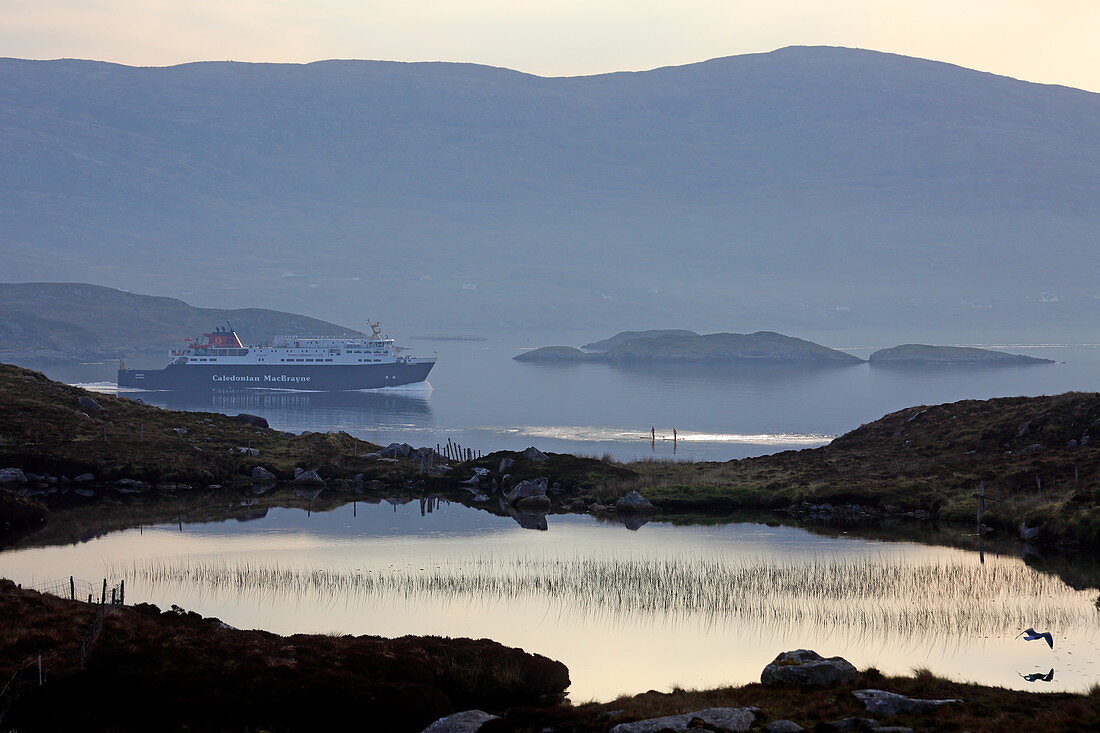 Stand-up paddle board and ferry in Tarbert Bay, Isle of Harris, Outer Hebrides