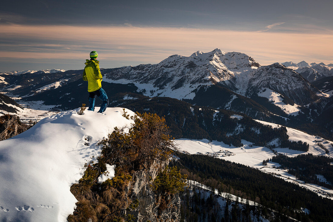 Mann an der Buchensteinwand in Fieberbrunn, Wilder Kaiser bei Winter im Sonnenuntergang, Tirol, Österreich